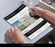 A real estate open house flyer being held by two hands over a gray table, with a glass of water and a stack of papers nearby. The flyer features a black and white design with property photos and text.